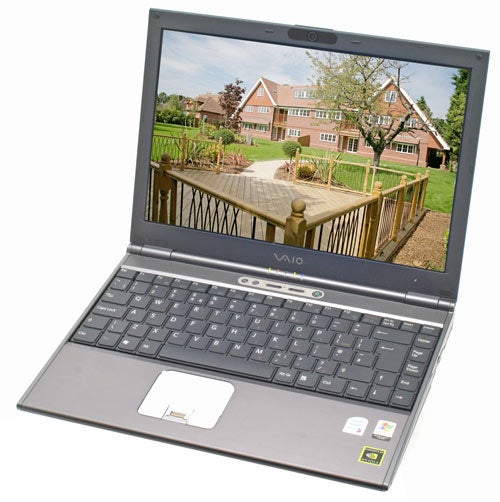 Sony Vaio VGN-SZ2XP laptop open on a desk displaying a wallpaper of a house with a garden on its screen, showcasing the device's sleek design and screen clarity.