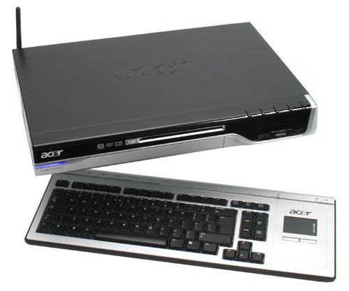 Acer Aspire Idea 500 Media Center System with a wireless keyboard and remote control, showcasing its sleek black design and front panel ports.