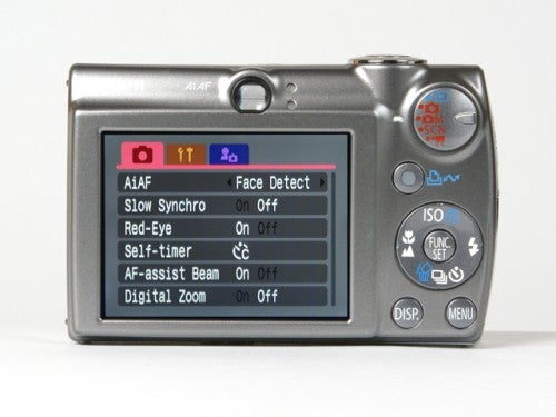Canon Digital IXUS 850 IS camera showing its back LCD screen with menu options including face detect, red-eye correction, and digital zoom settings.