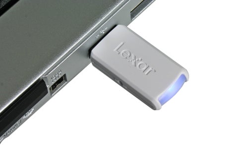 Lexar JumpDrive FireFly USB flash drive plugged into a laptop's USB port.