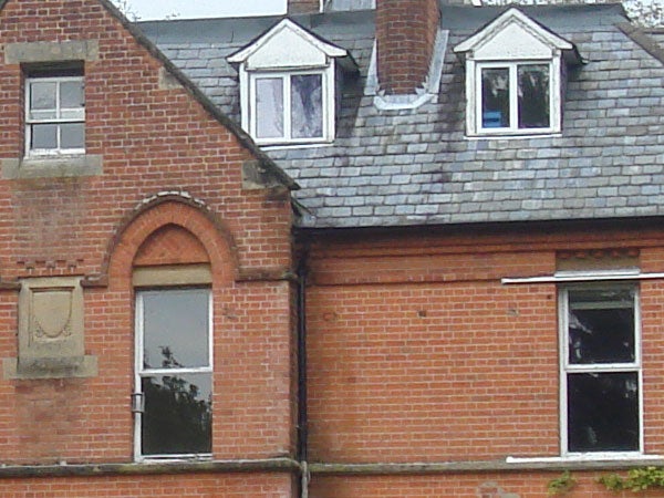 Photograph of a brick house with multiple windows, showcasing the image quality and color reproduction of the Sony Cyber-shot DSC-T10 camera.