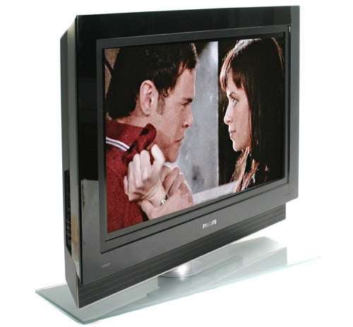 Philips Cineos 37PF9731D 37-inch LCD TV on a glass stand displaying a movie scene with two actors having a conversation.
