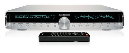 Slim Devices Transporter high-fidelity network music player with a black and green display showing track information, flanked by blue VU meters, in front of a white background, including a remote control.