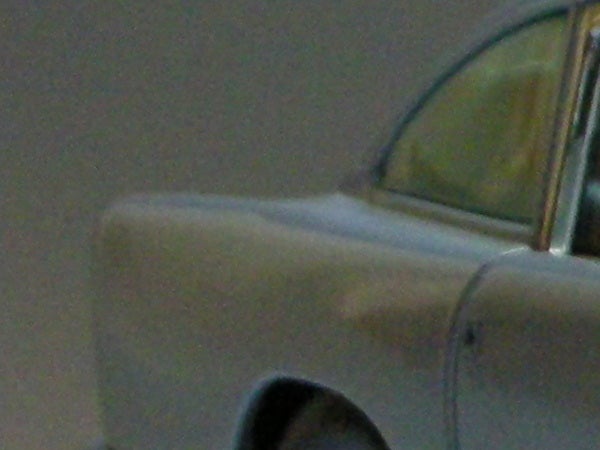 Blurred image of a car highlighting the limitations of the Nikon Coolpix S7c in low-light conditions or at high zoom levels.