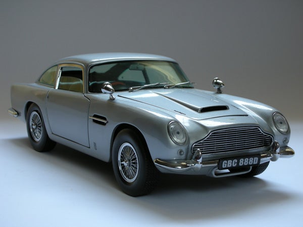 Silver Aston Martin model car on a neutral background.