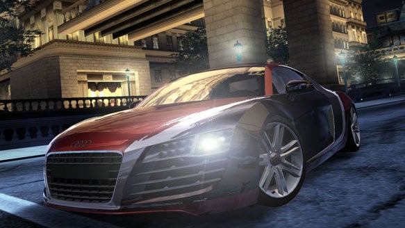 Screenshot of a red Audi R8 from the video game Need for Speed: Carbon showing the car racing through a city street at night.