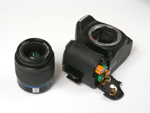Disassembled Samsung GX 1L DSLR camera with lens.