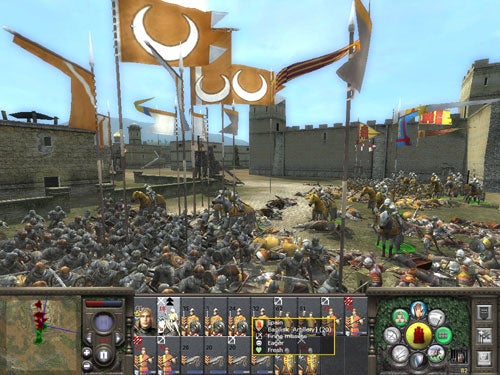 Screenshot of gameplay from Medieval 2: Total War showing a battle scene with multiple units engaged in combat within a fortified city, under siege with flags flying overhead, and the game's user interface and controls visible at the bottom.