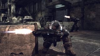 Screenshot from the video game Gears of War showing a character taking cover and firing a weapon in a battle-scarred urban environment.