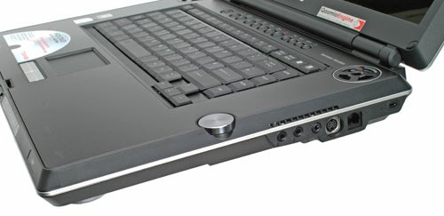 Close-up of the Toshiba Qosmio G30-102 laptop left-side ports, featuring USB ports, audio jacks, and other connectivity options, with the laptop partially open, displaying the keyboard and screen.