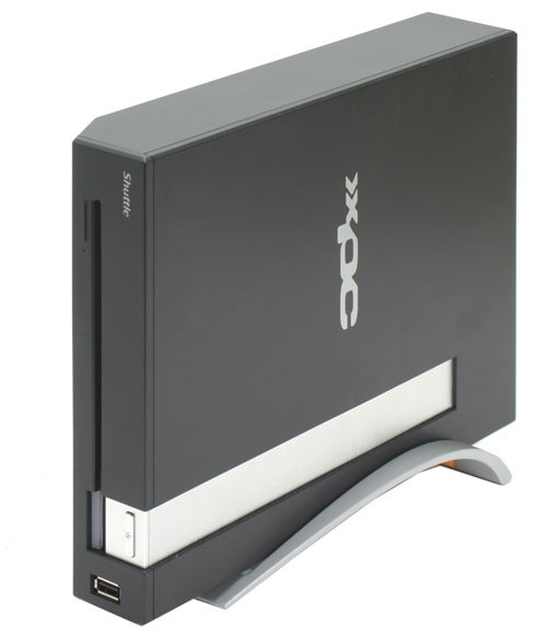Shuttle XPC X100 small form factor desktop computer standing upright on its stand with a sleek black and silver design and the XPC logo on the side.