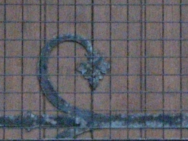Low-light photo sample showing a heart-shaped drawing on a tiled surface, taken with a Ricoh Caplio R5, exhibiting noticeable image noise and grain.