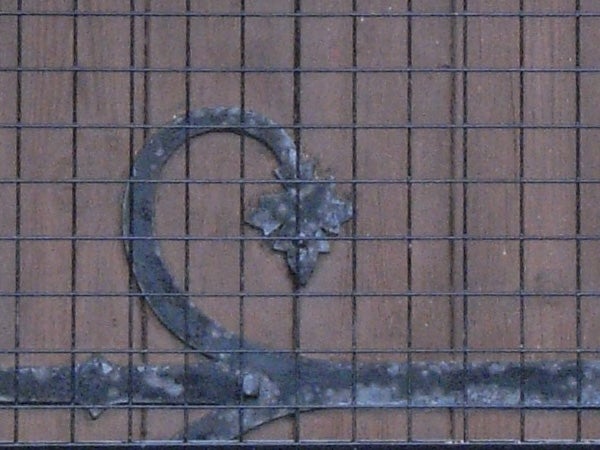 Image of a decorative metal heart with a textured finish, affixed to a brick wall, displaying the potential zoom or macro photography capability of the Ricoh Caplio R5 camera.
