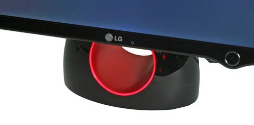 Close-up of the distinctive circular stand with a red light of the LG L1900R 'Ring' monitor, showing a part of the sleek black monitor above.