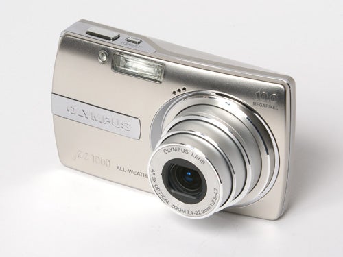 Olympus mju 1000 10MP Compact Camera in silver color, featuring a retractable lens and labeled as an all-weather device displayed on a white background.
