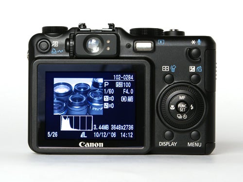 Canon PowerShot G7 digital camera back view showing LCD screen with photo preview and camera settings displayed.