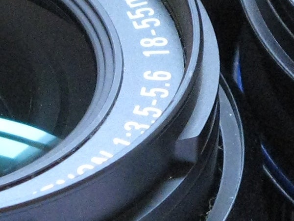 Close-up of a Canon camera lens with focus on the aperture size markings.
