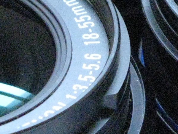 Close-up of a Canon camera lens focusing ring showing aperture settings.