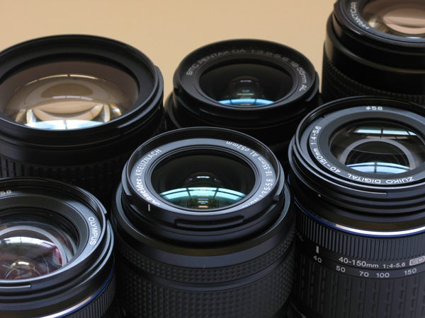 A collection of camera lenses with various focal lengths and apertures, likely interchangeable lens for a DSLR or mirrorless camera system.
