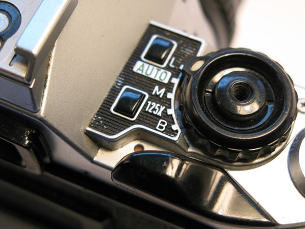 Close-up view of the mode selection dial on a Canon PowerShot G7 camera displaying the various shooting modes including Auto, Manual, and Bulb.