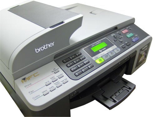 Brother MFC-5460CN Multi-Function Printer with an open paper output tray displaying fax, copy, and print control panel with a green-lit LCD screen.