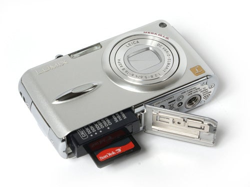 Panasonic Lumix DMC-FX01 digital camera with open battery compartment revealing the battery and memory card.