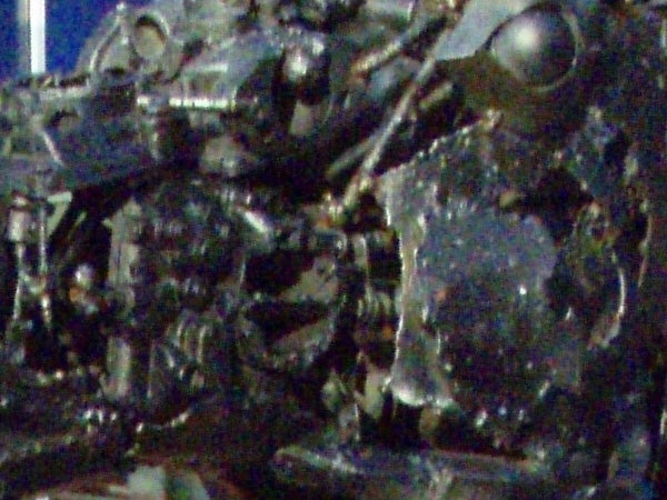 A low-resolution image showing a heavily pixelated subject that appears to be electronic or mechanical components, making it difficult to distinguish details.