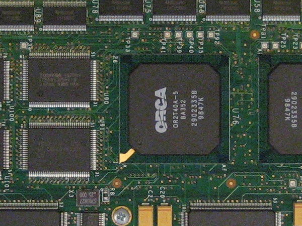 Close-up of a circuit board with integrated circuits and electronic components, possibly from inside a digital camera like the Canon Digital IXUS 65.