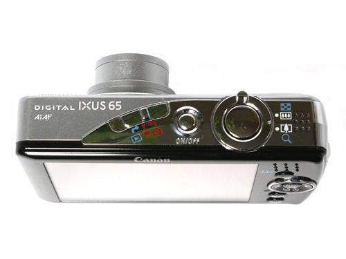 Canon Digital IXUS 65 camera displayed against a white background, showing the top view with power button, shutter button, zoom control, and mode selection wheel visible.