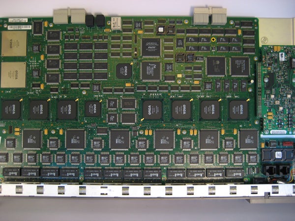 Circuit board with multiple electronic components including integrated circuits, capacitors, and connectors, representing internal hardware possibly related to or used in a Canon Digital IXUS 65 camera.