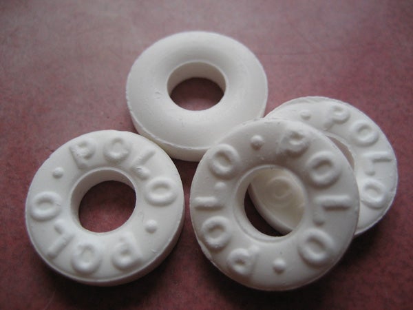 Four white, round mint candies with 