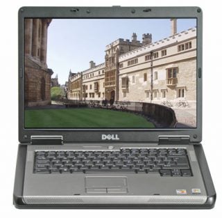 Dell Latitude 131L laptop on a white background with the screen displaying a street view photograph, showing the laptop's keyboard and touchpad.