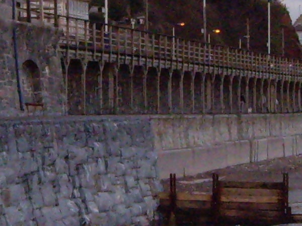 Image of a stone pier with metal railings taken during twilight using a Pentax Optio T20 camera, showing potential low-light performance capabilities.