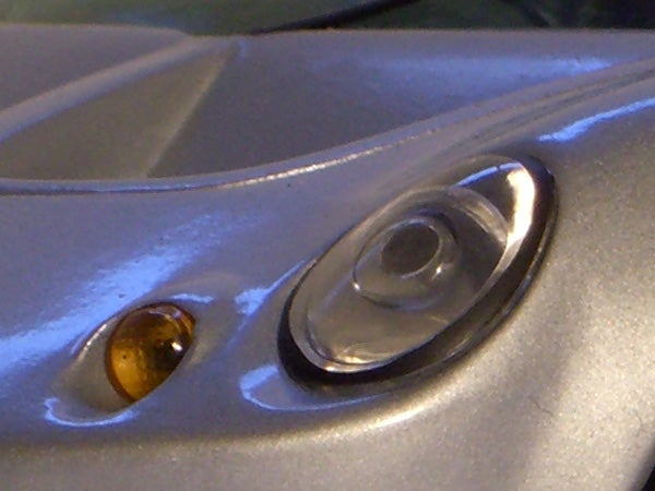 Close-up of a car headlight and turn signal with a reflected surface, not related to the Casio Exilim EX-S770 camera.