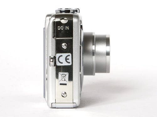 Side view of a Sony CyberShot DSC-W70 digital camera showing the DC IN port and CE marking on its silver body.