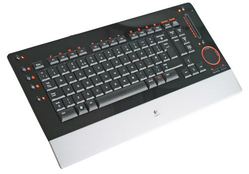 Logitech diNovo Edge Keyboard on white surface, highlighting the sleek black keys, orange illuminated accents, touchpad, and multimedia controls.