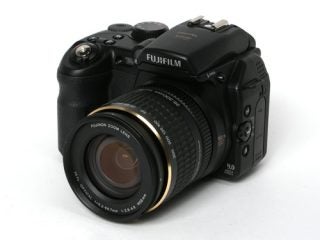 Fujifilm FinePix S9600 digital camera with a black body and Fujinon zoom lens on a white background.