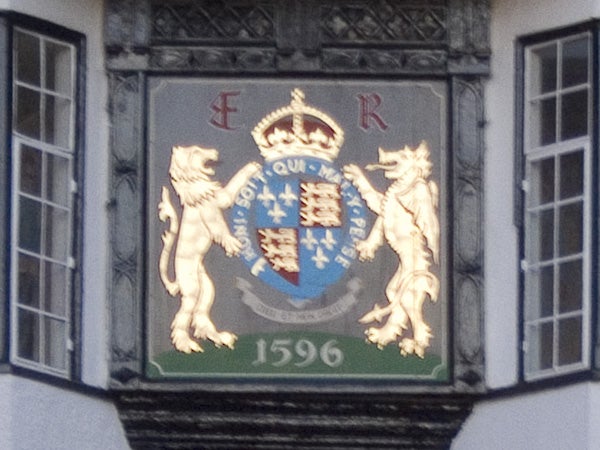 Coat of arms with two lions and central shield on the facade of a building, featuring the date 1596 and initials E R above.