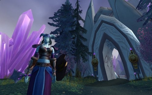 Screenshot from World of Warcraft: The Burning Crusade showing a female Night Elf character in front of The Exodar, surrounded by purple crystals and trees.