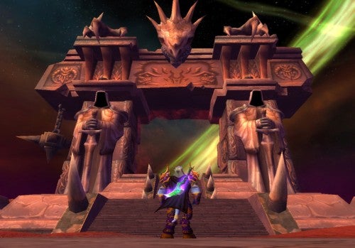 A player-character in full armor stands before the Dark Portal in World of Warcraft: The Burning Crusade, with the portal's greenish hue illuminating the sky.