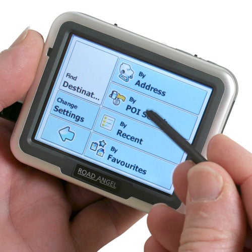 A hand holding the Road Angel Navigator 6000 GPS device with the screen displaying menu options including "Find Destination", "Change Settings", and searching by "Address", "POI", "Recent", and "Favourites". A stylus is being used to operate the touchscreen.
