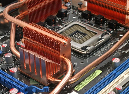 Close-up of Asus Striker Extreme motherboard highlighting the CPU socket area with copper heat pipes and heat sinks.