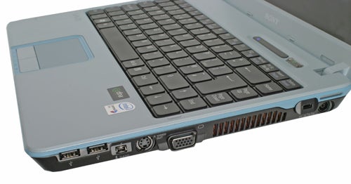 Sony VAIO VGN-C2SL laptop showing its keyboard, trackpad, and the left side interface ports including USB, VGA, and Ethernet ports.