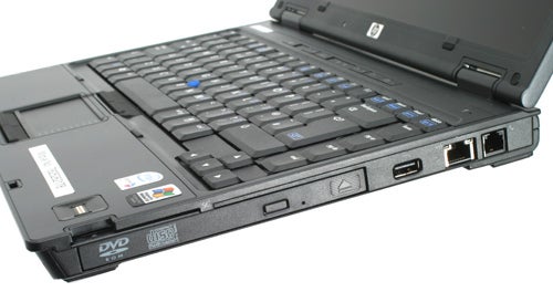 HP Compaq nc6400 laptop with partly open lid, showing keyboard, touchpad, and left-side ports including USB and DVD drive.