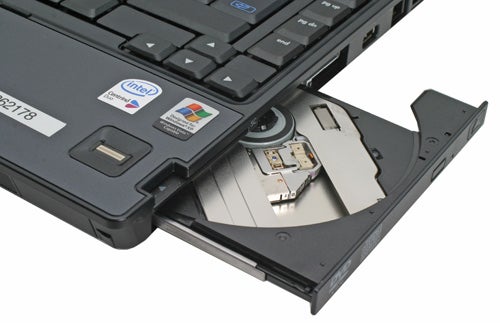 HP Compaq nc6400 laptop with an open optical disk drive showing a CD inside.
