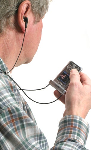 Man using MPMan mp3 player with earphones plugged in, navigating the device's screen.
