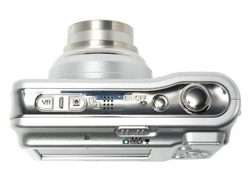 Top view of a Nikon CoolPix L5 digital camera showing the control buttons for vibration reduction, scene mode, and power, along with the built-in microphone and speaker.