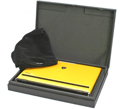 Asus Lamborghini VX2 laptop in bright yellow with Lamborghini logo, presented in a luxurious black box with a protective black cloth.
