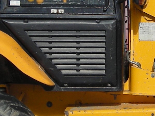 Close-up of a yellow construction vehicle's ventilation grill and part of the wheel housing.