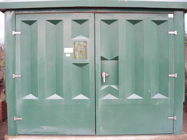 Green metal double doors with a poster in the center.